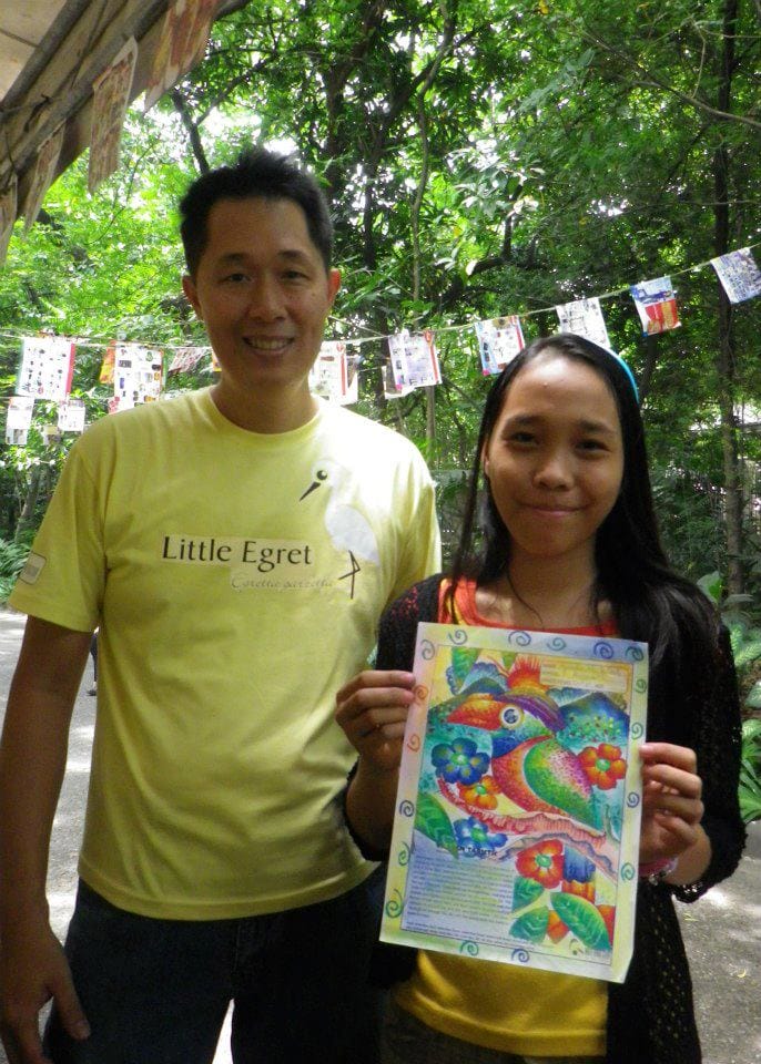Mike Lu posing with one participant and her finished coloring sheet. Photo by Tinggay Cinco.